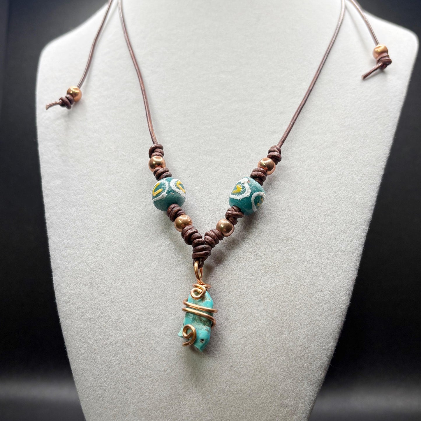 Necklace with turquoise and glass beads on a mannequin bust.