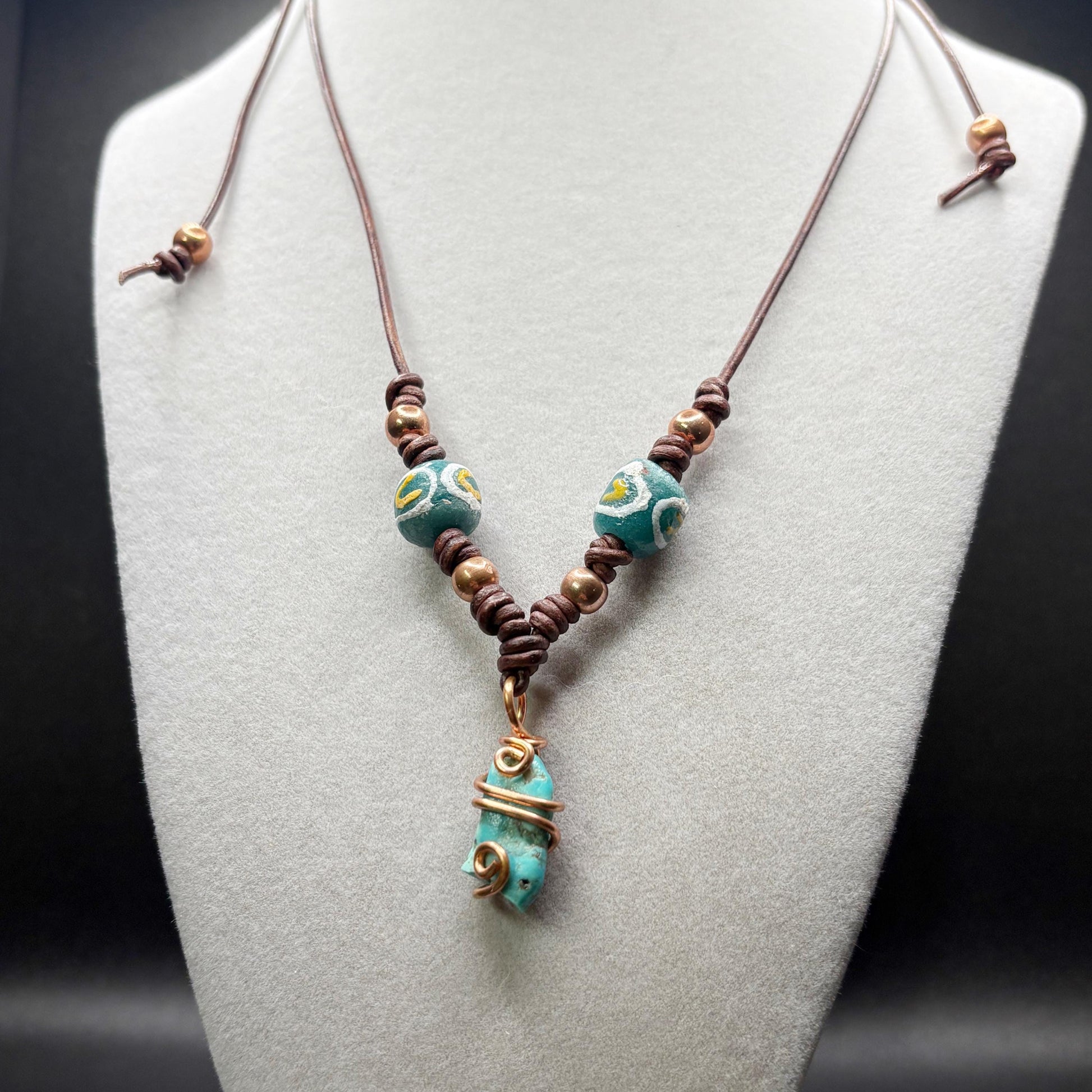 Necklace with turquoise and glass beads on a mannequin bust.