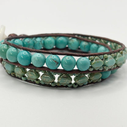 Turquoise beaded bracelet with brown leather strap on a white background