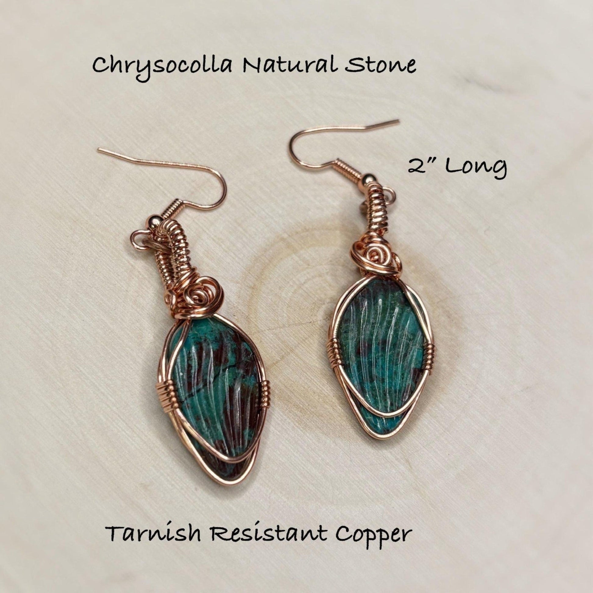 Chrysocolla natural stone earrings with tarnish resistant copper setting on a beige background.