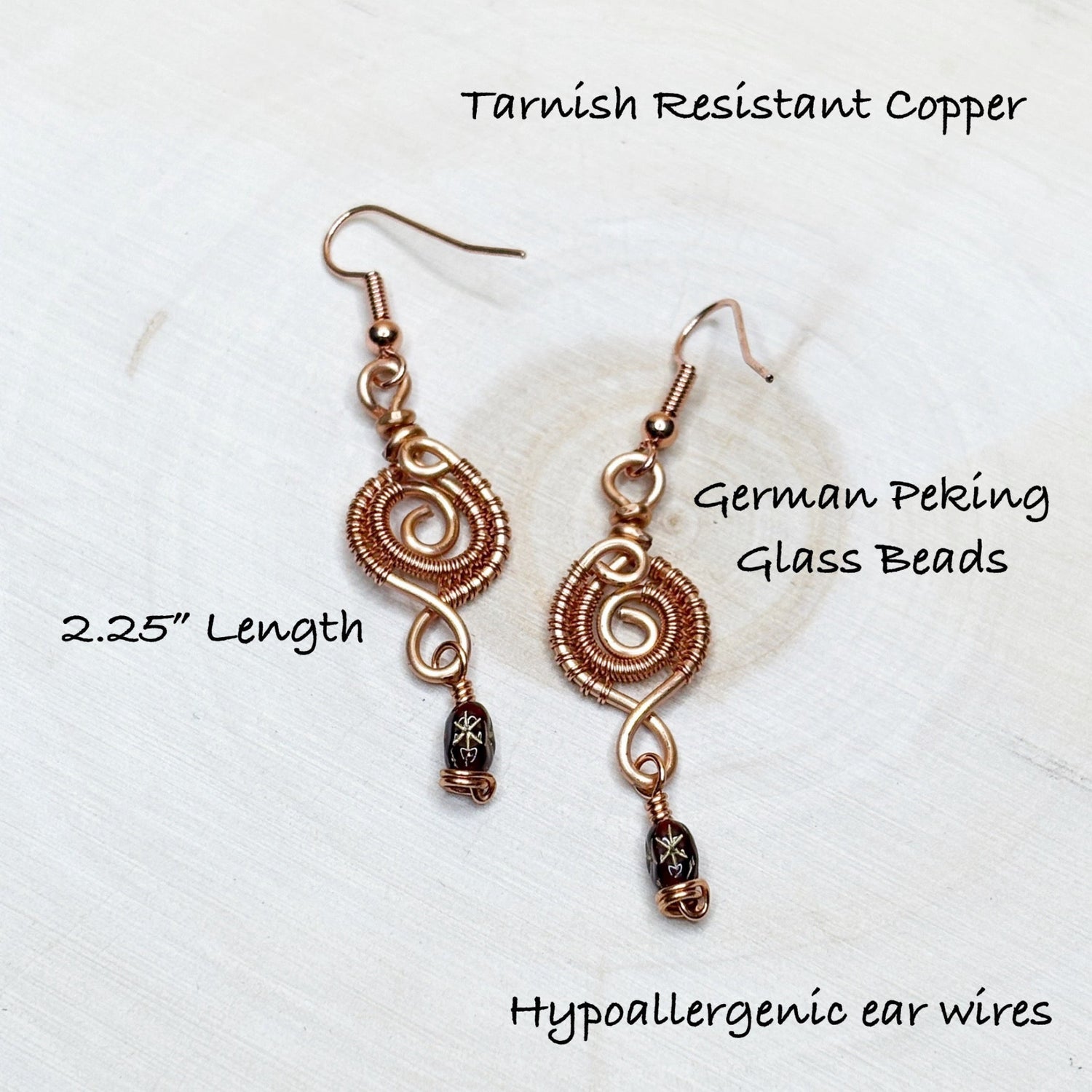 Copper earrings with German Peking glass beads on a white background