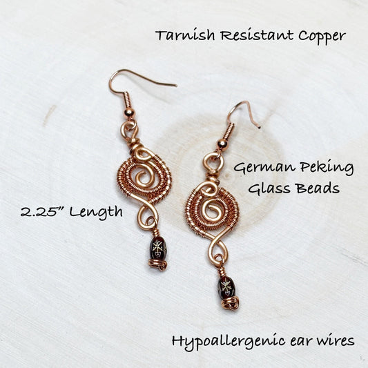 Copper earrings with German Peking glass beads on a white background