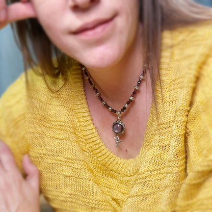 Person wearing a yellow sweater and a necklace with a pendant.