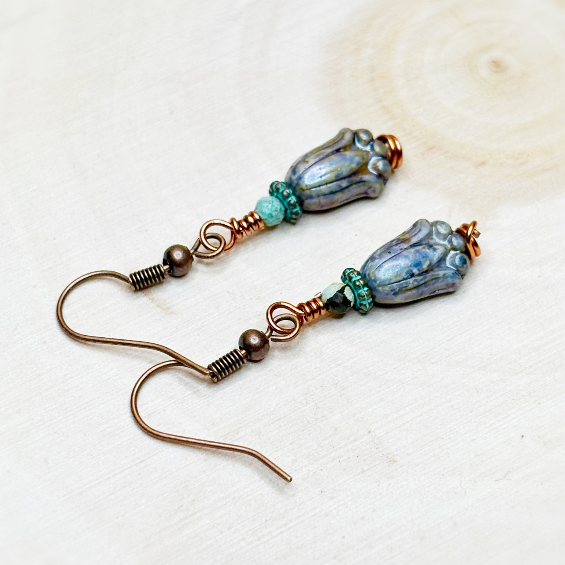 Pair of earrings with blue and brown beads on a light background