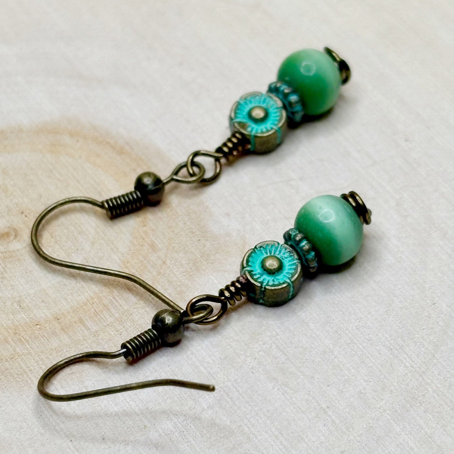 Pair of green beaded earrings on a light background