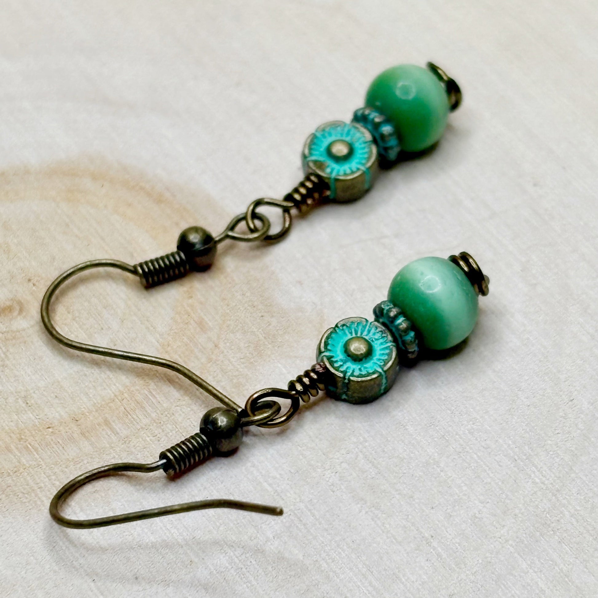 Pair of green beaded earrings on a light background