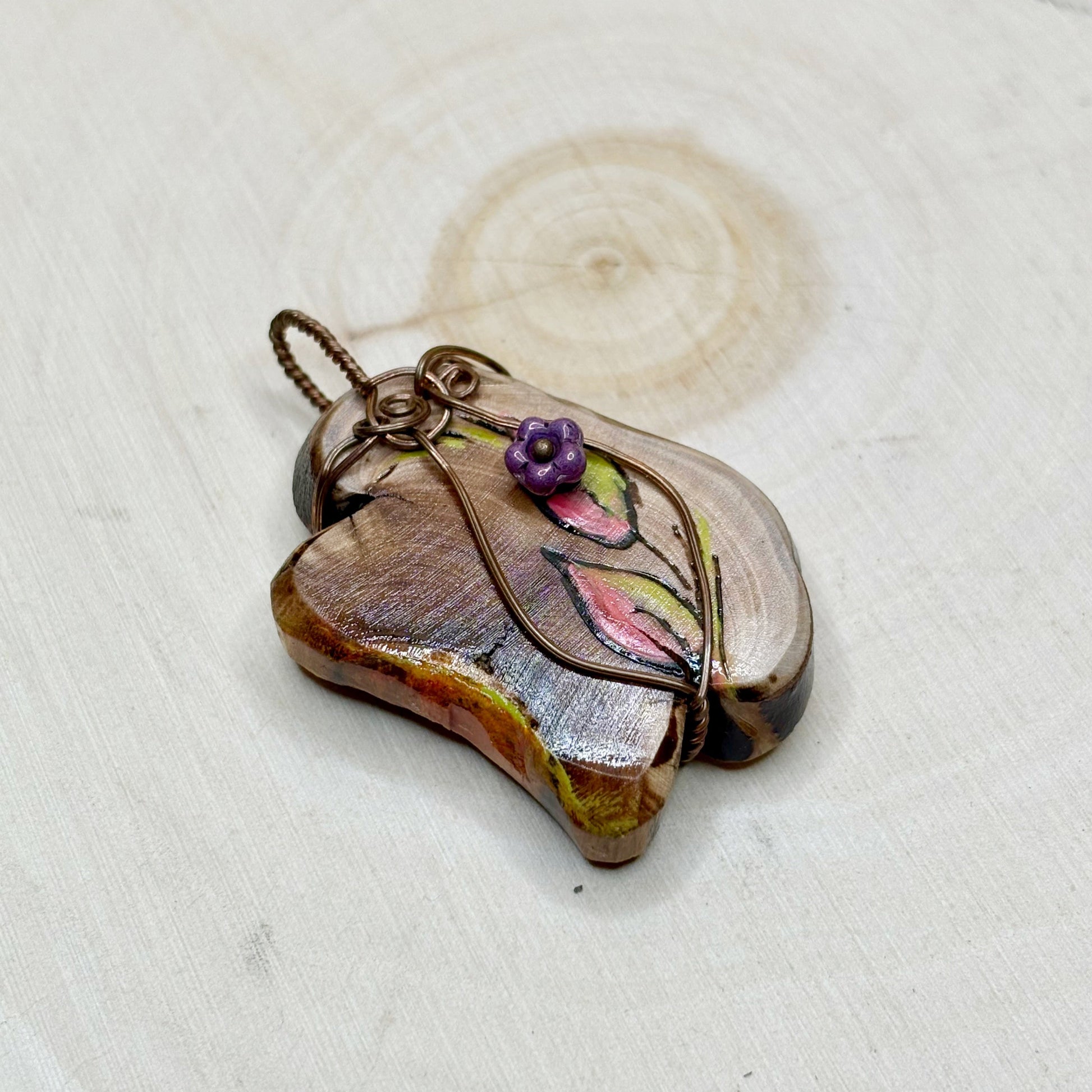 Handmade pendant with floral design on a white background