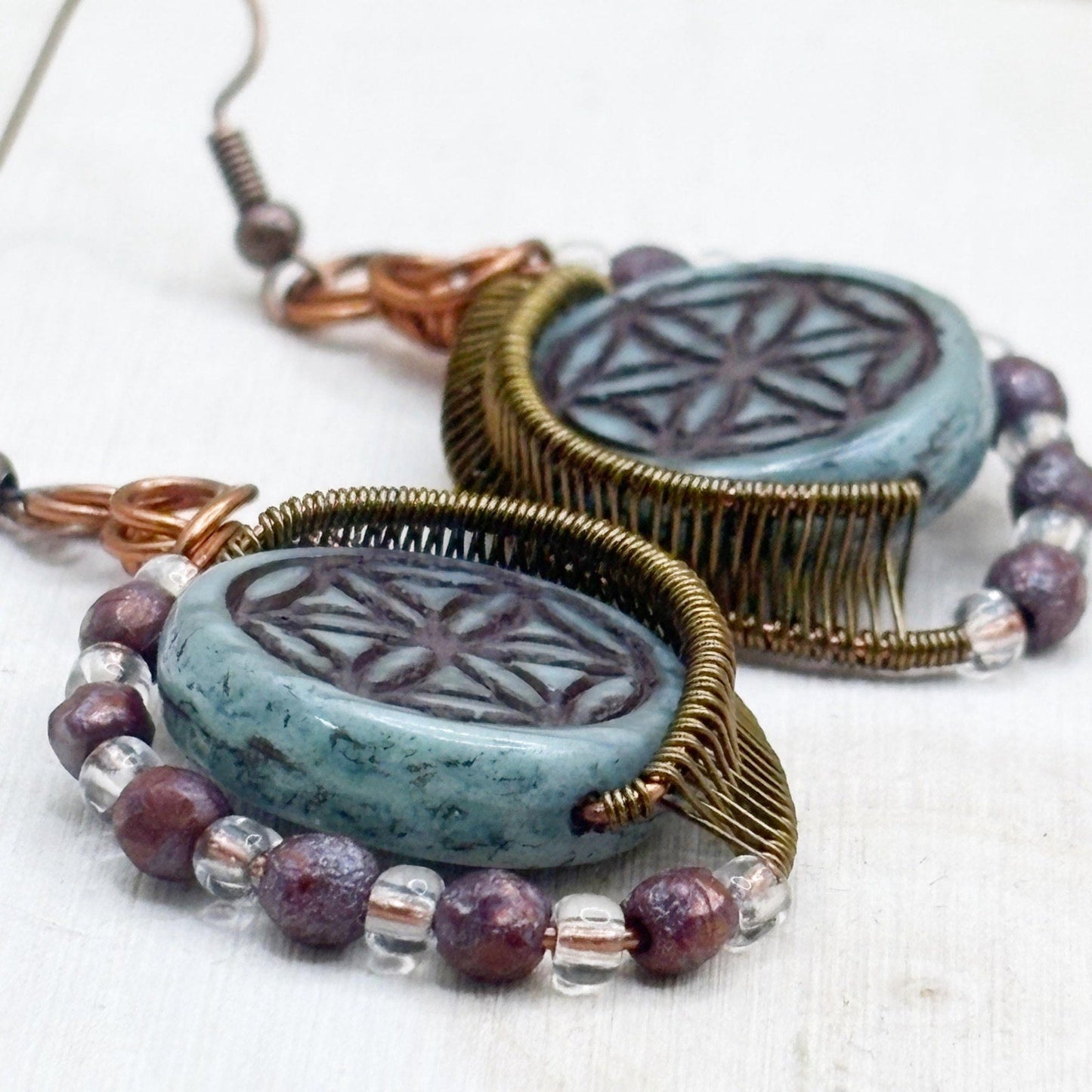 Pair of earrings with turquoise glass beads and beaded accents on a white background