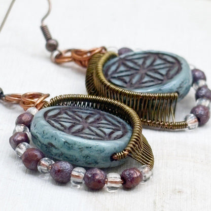 Pair of earrings with turquoise glass beads and beaded accents on a white background