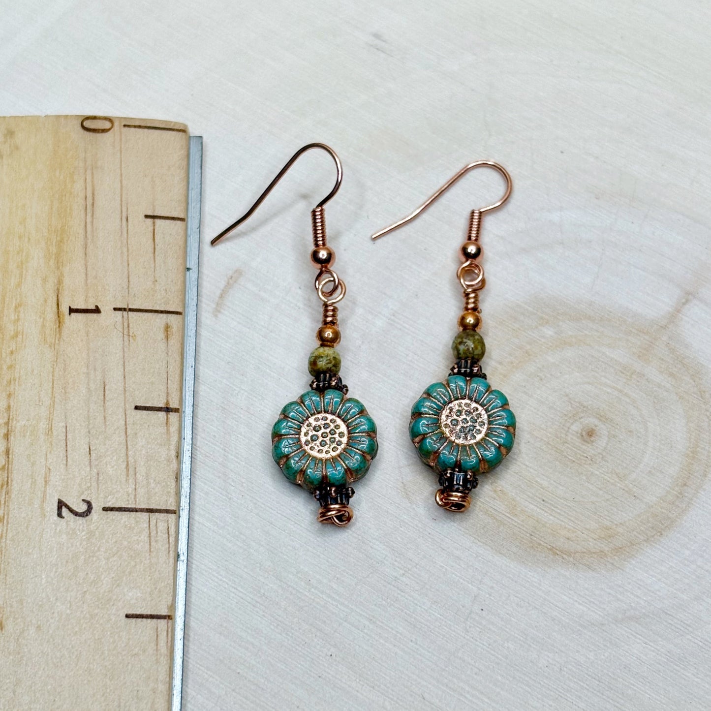 Ruler with earrings showing the 2 inch length of copper jewelry
