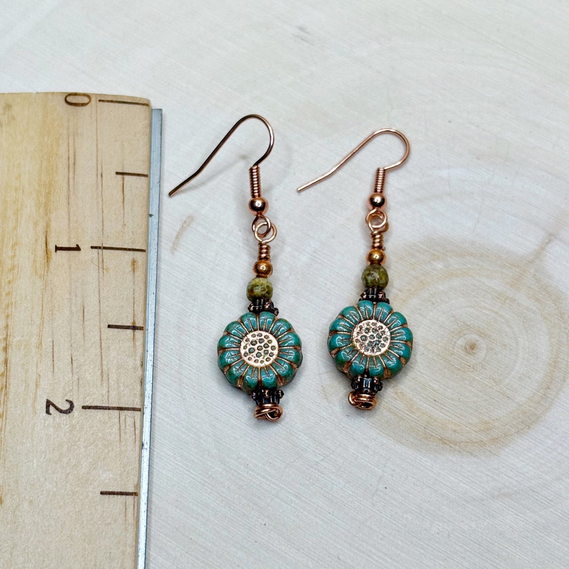 Ruler with earrings showing the 2 inch length of copper jewelry