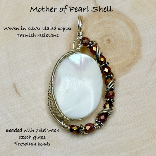 Mother of pearl shell pendant with gold wash czech glass firepolish beads on a wooden background