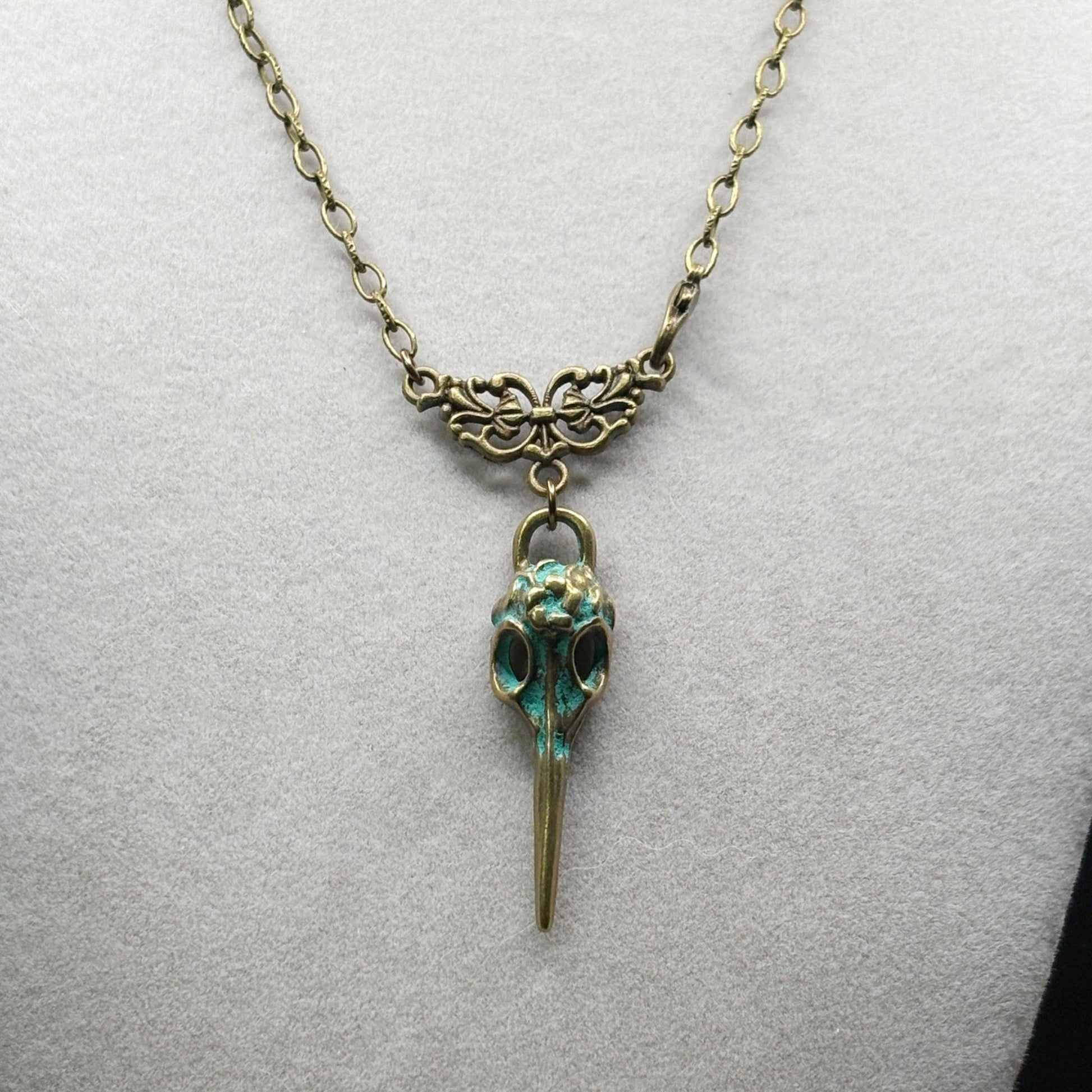 Necklace with a bird skull pendant on a light gray background