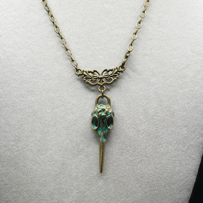Necklace with a bird skull pendant on a light gray background