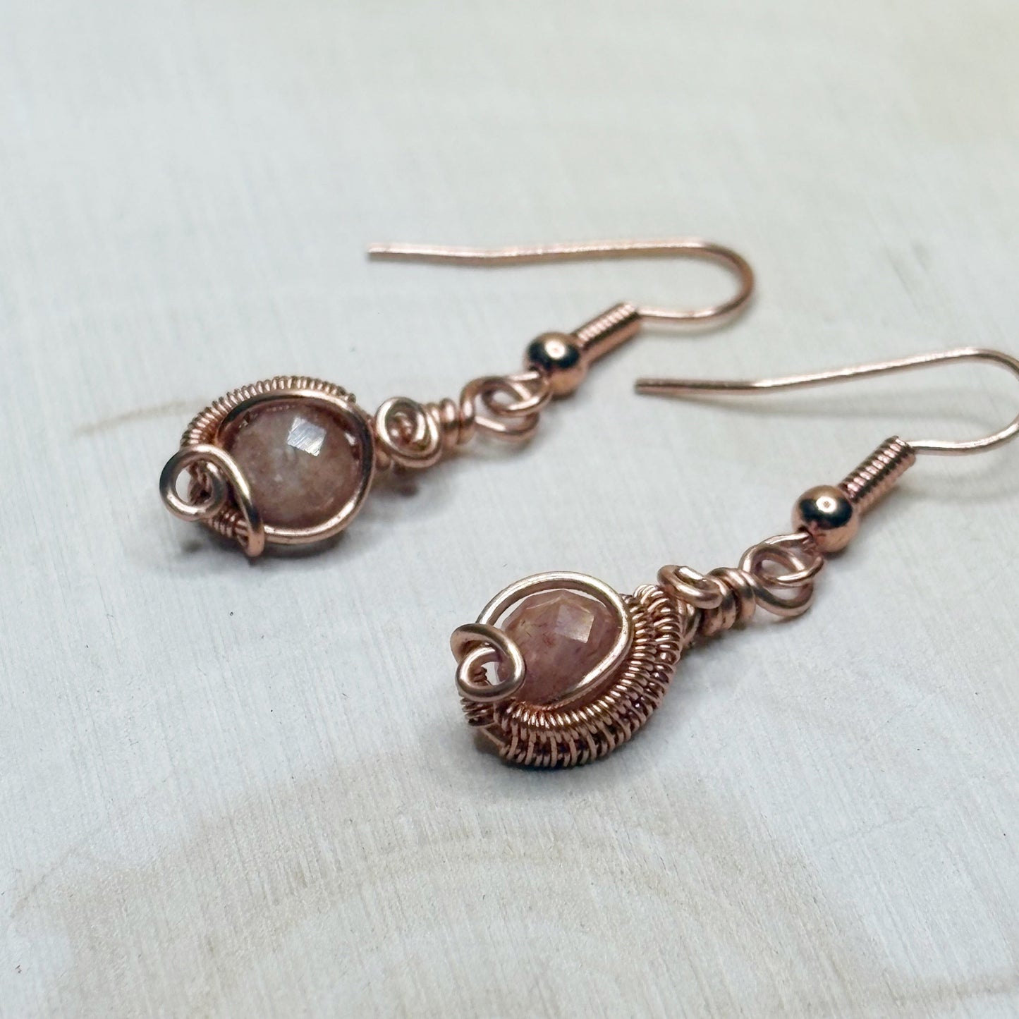 copper earrings with gemstones on a light background